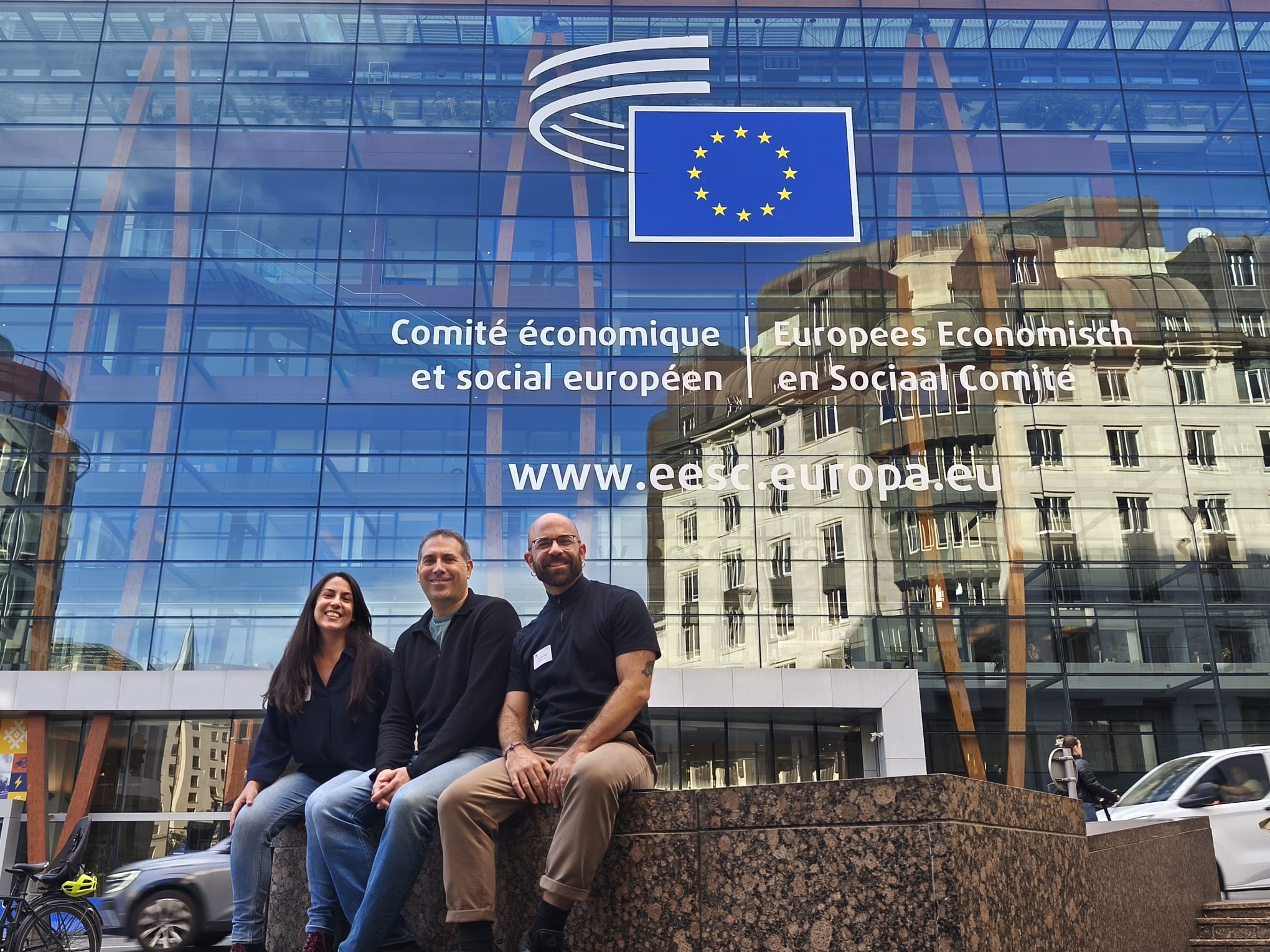 Tres personas frente a edificio Comisión Europea.